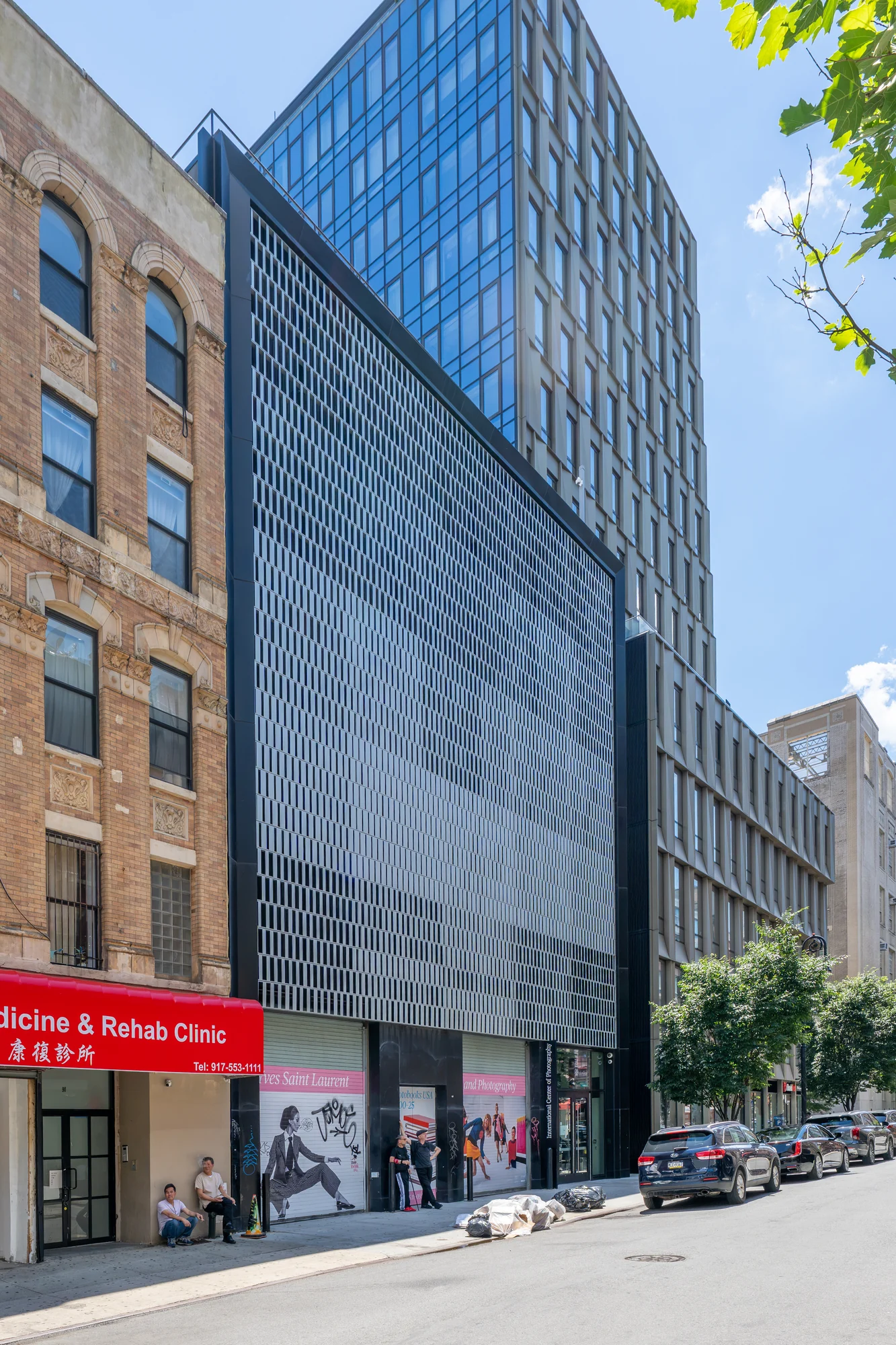 The tall facade of the International Center of Photography at 84 Ludlow Street, with a patterned metal screen above the street-level entrance.
