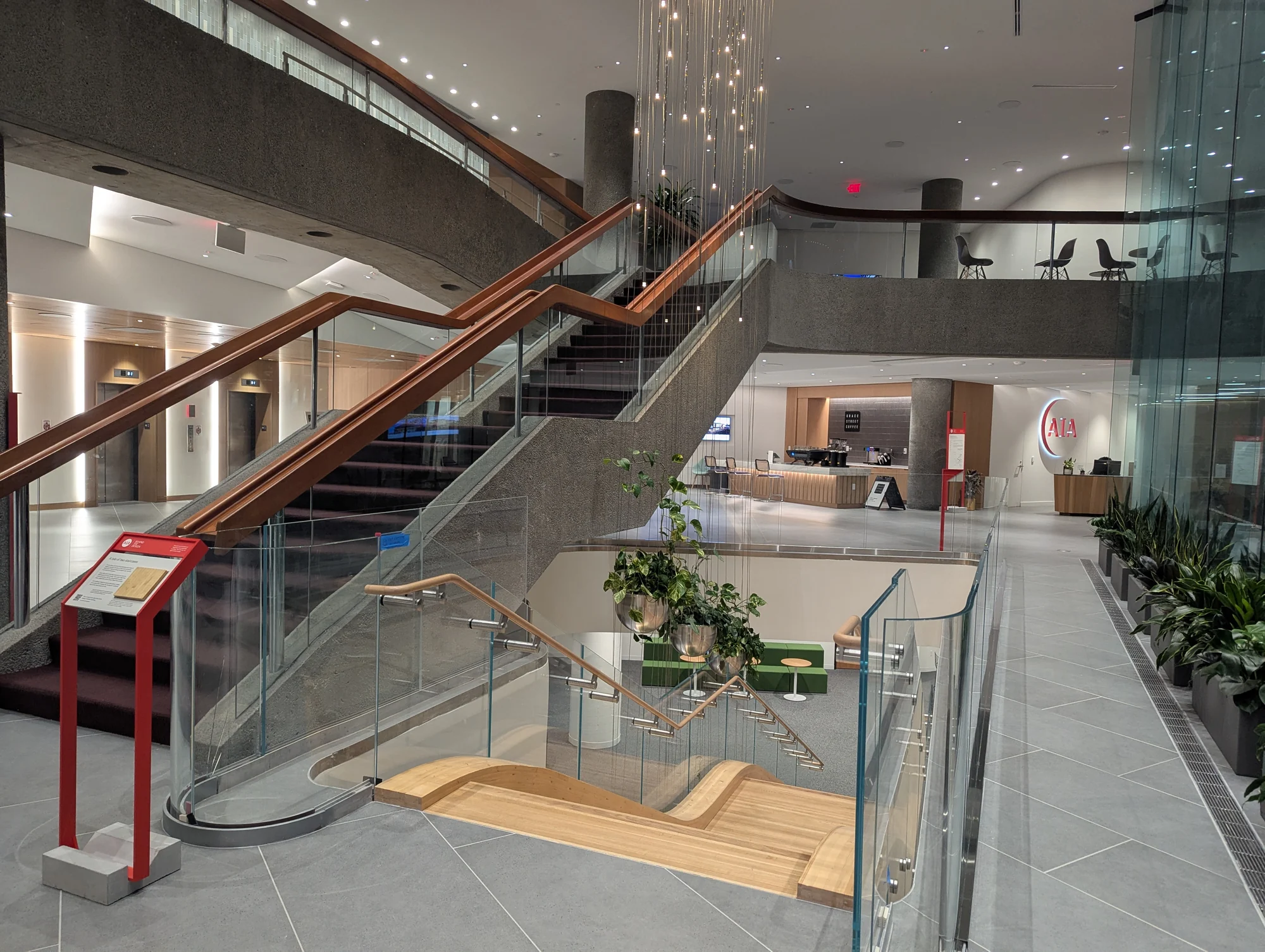 Concrete and timber staircases, glass balustrades and a reception area inside the American Institute of Architects headquarters.